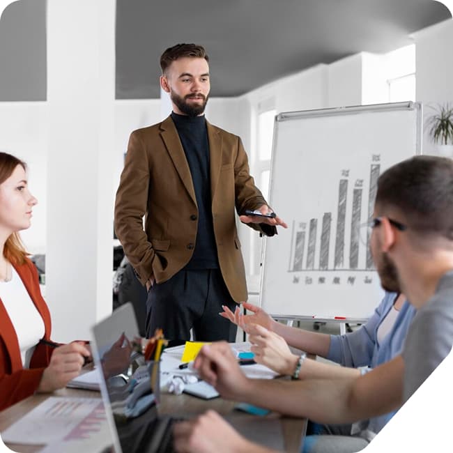 A speaker leading a workshop in front of a whiteboard