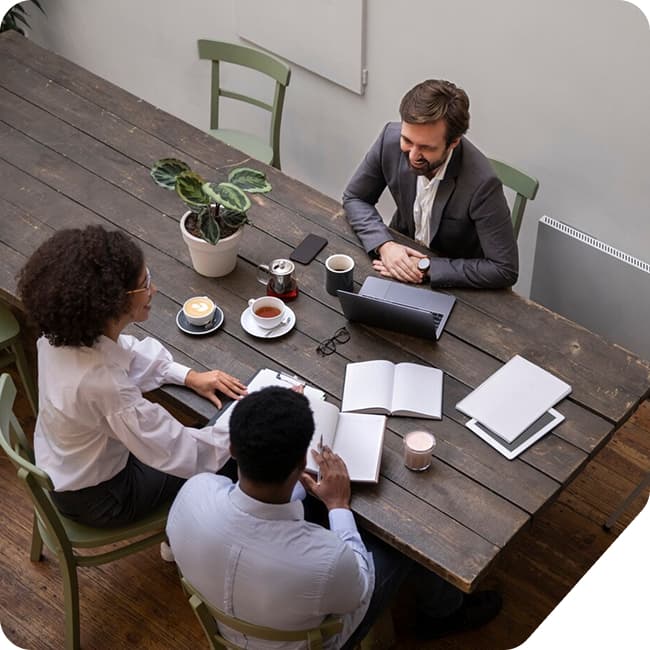 Colleagues in conversation around a wooden table