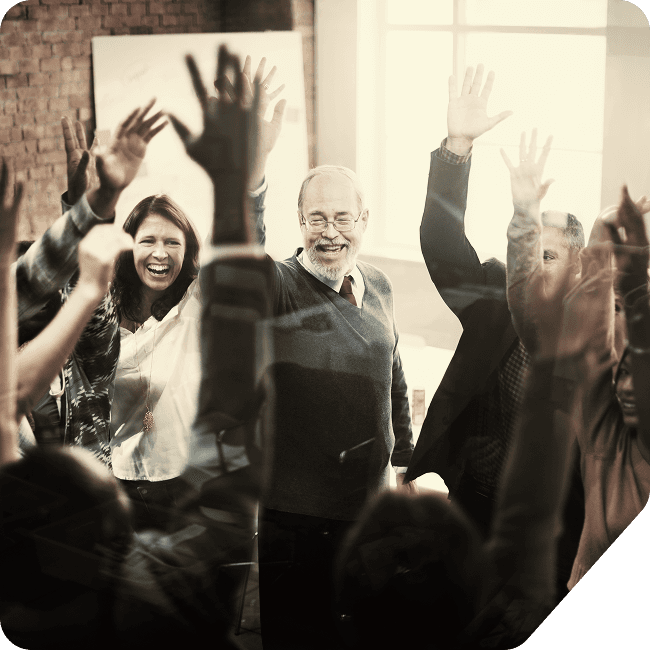 A joyful gathering of people with hands raised